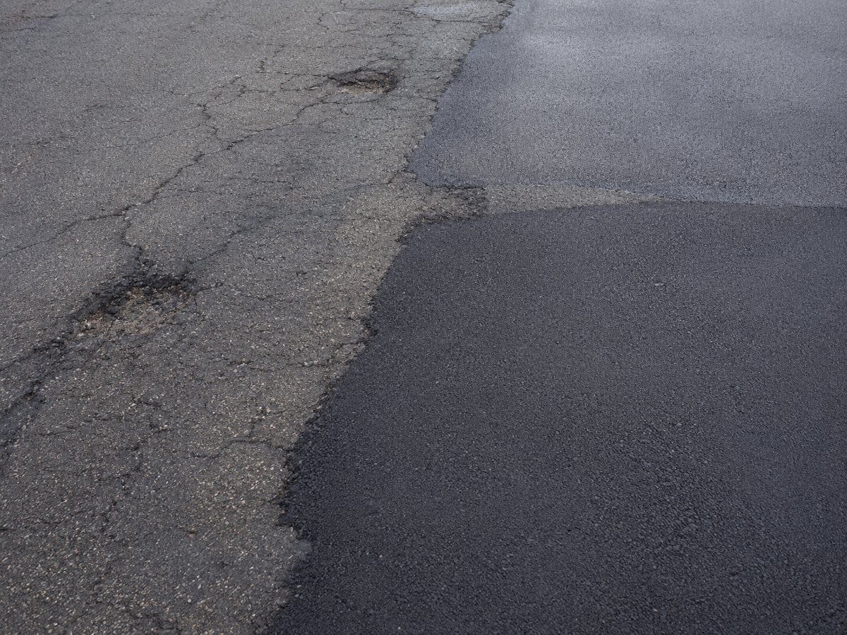 General asphalt repairs in Madison WI showing worn asphalt and repaired pavement sections
